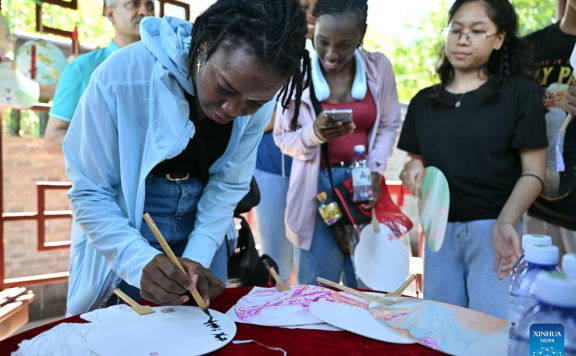 Foreigners learn to make traditional Chinese lacquer fans in Haikou